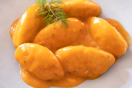 close up dumpling with tomato sauce in a white plate on a tableの写真素材