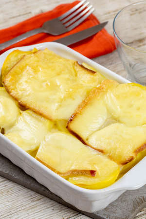 potato with raclette cheese on wooden tableの写真素材