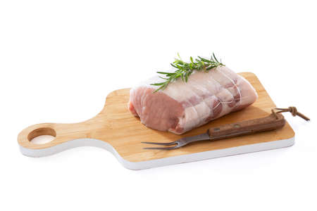 raw pork roast on a board on a wooden backgroundの写真素材