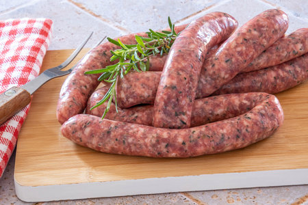 sausages with raw herbs on a wooden board on a tableの写真素材