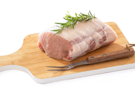 raw pork roast on a board on a wooden backgroundの写真素材
