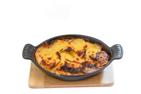 Potato gratin in a baking dish on a white background.の写真素材