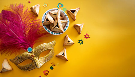 Purim celebration concept (Jewish carnival holiday). Traditional hamantaschen cookies and carnival maskの素材