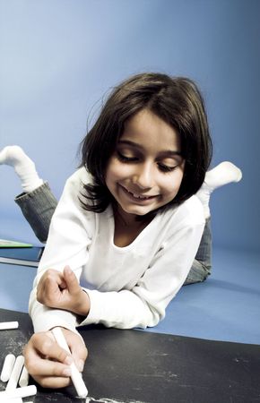little girl writing on board on the floorの写真素材