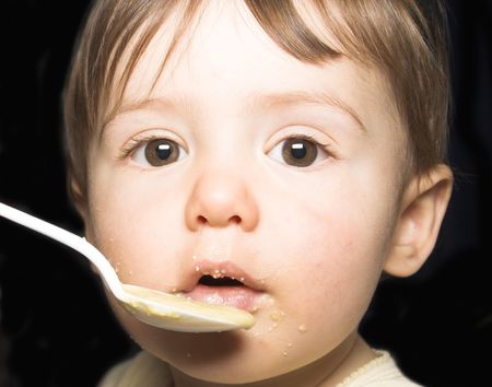  being fed with spoon by his motherの写真素材