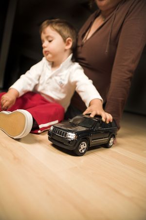 little boy and mother playing indoor with model carsの写真素材