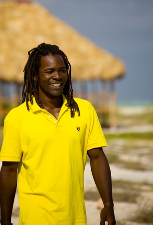black man with yellow t-shirt walking on the beachの写真素材