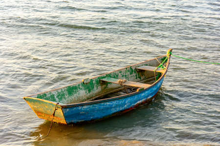 Old fishing boat and wood anchored in the waters of Buziosの写真素材
