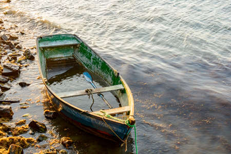 Old fishing and wooden boat stranded on the sea Buzios stonesの写真素材