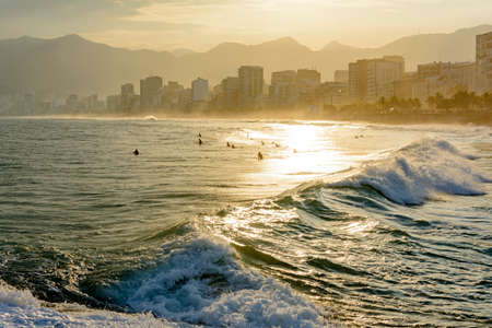 Sunset on Ipanema beach in Rio de Janeiro with the Leblon beach and Rio de Janeiro hills in the...