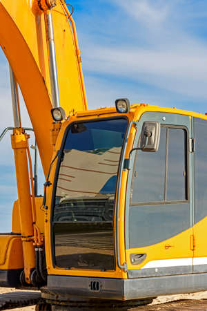 Excavator cabin and gears on the beach with blue sky and sea in the backgroundの写真素材