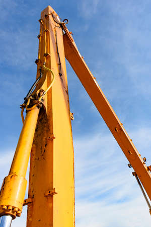 Detail of the joints and gears of a crane with blue sky in the background
