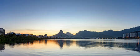 Panoramic image of the late afternoon at Lagoa Rodrigo de Freitas in Rio de Janeiro with its mountains, buildings and characteristic outlineの写真素材