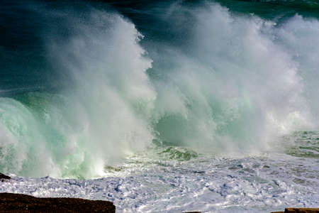 Wave crashing against rocks during stormの写真素材