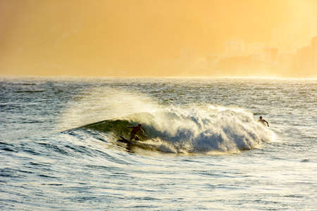 Surfing during the summer sunset at Ipanema beach in Rio de Janeiroの写真素材