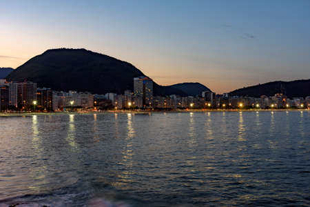 Copacabana Beach and Sugar Loaf seen at night with its buildings, lights, sea, hills and contoursの写真素材