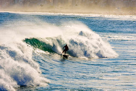 Surfer and wave with water spray at Ipanema beach in Rio de Janeiroの写真素材