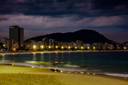 Copacabana Beach and Sugar Loaf seen at night with its buildings, lights, sea, hills and contoursのeditorial素材