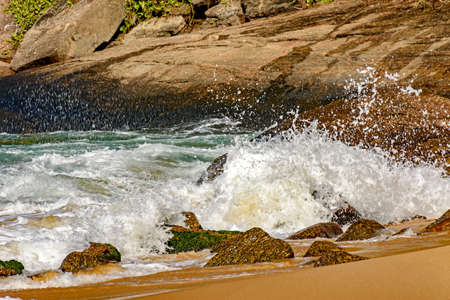 Wave crashing on the rocks of Red Beach beach at Urca, Rio de Janeiroの写真素材