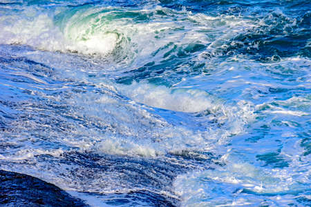 Sea water breaking over the stones on the beach