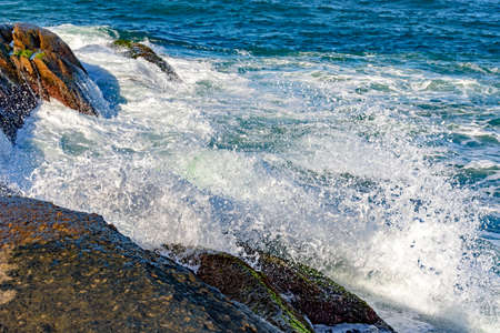 Sea water drops over the stones on the beachの写真素材