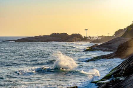 Waves and stones on Devil's beach in Ipanema, Rio de Janeiro at summer sunsetの写真素材