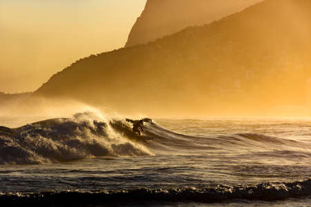 Surfer alone on the beach of Ipanema in Rio de Janeiro during the late afternoon
