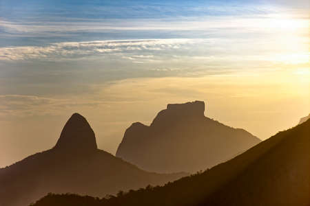 Silhuete of Gavea stone and Two Brothers hill with cloudy sky during sunsetの写真素材
