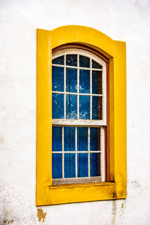 Old window made of wood in colonial style with yellow frame in Ouro Preto city, Minas Grerais, Brazilの写真素材