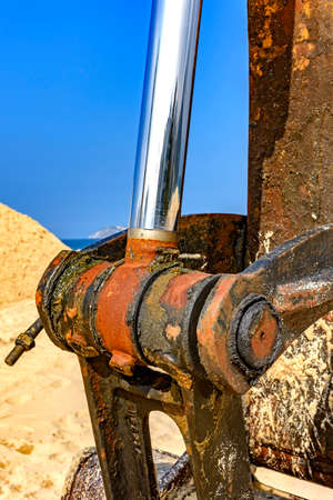 Detail of rusty and dirty oil gear from a bulldozer on the beach