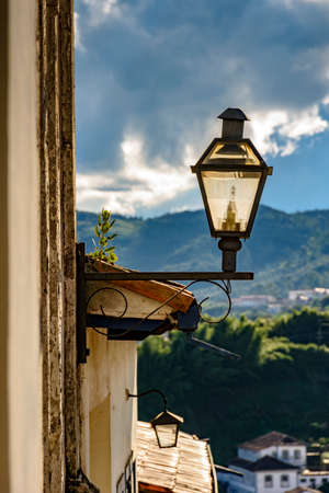Lantern stuck to the facade of an old colonial-style house during the late afternoon of the city of Ouro Preto in Minas Geraisの写真素材