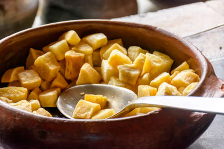 Portion of fried Cassava inside traditional crock pot in Brazilian country kitchenの写真素材