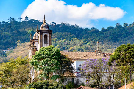 One of the many historic churches in baroque and colonial style from the 18th century amid the hills and vegetation of the city Ouro Preto in Minas Gerais, Brazilのeditorial素材