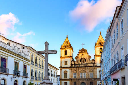 Old houses and churches in colonial and baroque style with a crucifix in the central square of the historic Pelourinho district in Salvador, Bahiaの写真素材