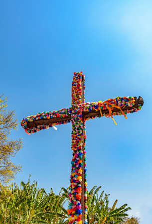 Crucifix decorated with flowers with blue sky in the background common in traditional religious festivals in the interior of Brazil in the state of Minas Geraisの写真素材