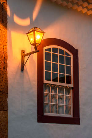 Old metal street lamp on the facade of a colonial-style house in the historic city of Tiradentes, Minas Geraisの写真素材