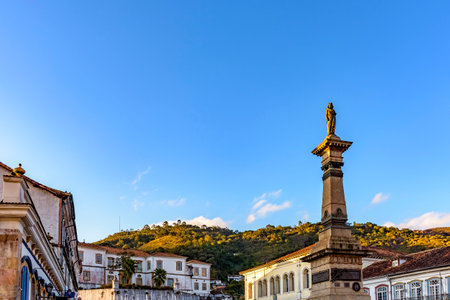 Central square of the historic town of Ouro Preto surrounded by colonial-style houses and hillsの写真素材