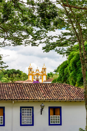 House and church among vegetation in the historic city of Tiradentes in Minas Geraisの写真素材