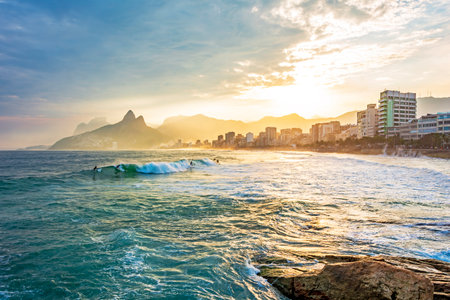 Sunset on Ipanema beach in the city of Rio de Janeiro with the mountains in the backgroundの写真素材