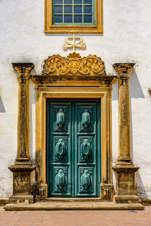 Entrance of historic baroque church with large wooden door and ornaments around in the city of Olinda, Pernambucoの写真素材
