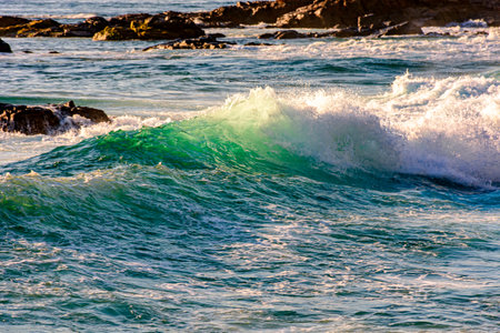 Small waves breaking on the beach in Salvador, Bahia during sunsetの写真素材