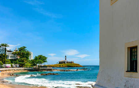 Porto da Barra beach in Salvador with the Barra Lighthouse and the city buildings in the backgroundの写真素材