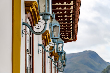 Several antique metal lanterns decorating the historical facade of a colonial-style house in the city of Ouro Preto.の写真素材