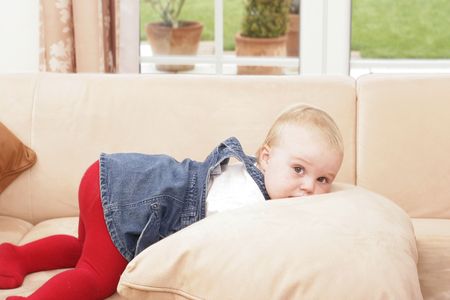 Twenty month old  is playing on the sofa