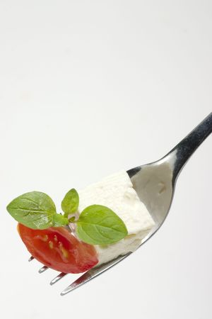 fork with feta, tomato and basil