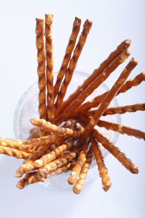 Saltsticks in a glass on white background