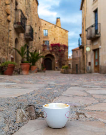 Cup of coffee in the middle of a Mediterranean streetの写真素材