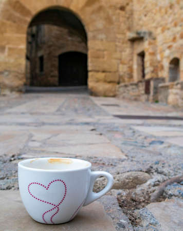 Cup of coffee in the middle of a Mediterranean streetの写真素材