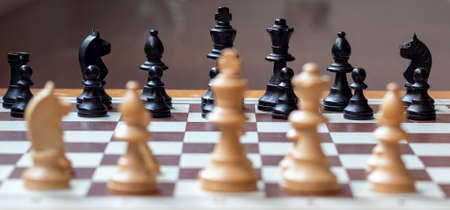 Wooden chess pieces on its classic chessboard