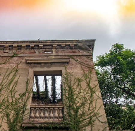 Abandoned facade with window and dramatic color skyの写真素材